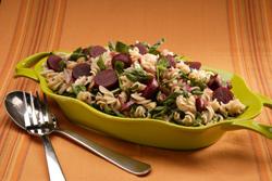 Beet and pasta salad in a colorful serving dish.